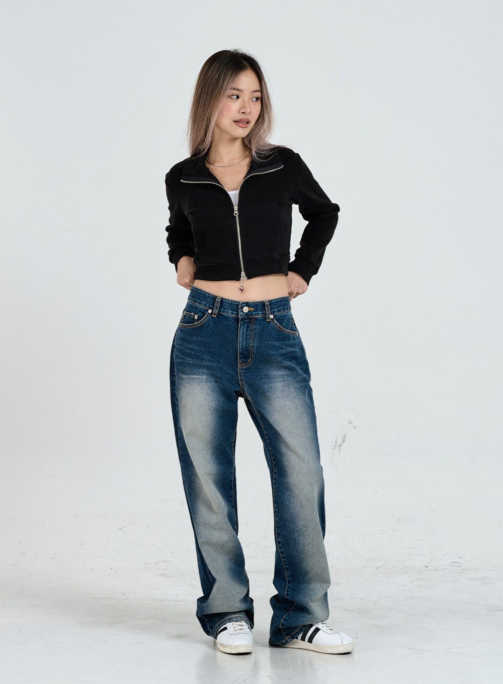 Wide Leg Faded Color Denim Pants CO11 in blue gradation, full-body slight-angle front shot on model, hand on hip, wide leg silhouette with faded wash, black crop jacket, white sneakers.
