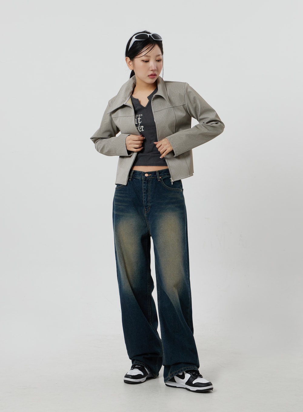 Dark Wash Jeans CF303 in blue, full-body three-quarter shot on model looking down, wide-leg indigo denim with golden washed fade, styled with beige jacket and graphic crop tee.