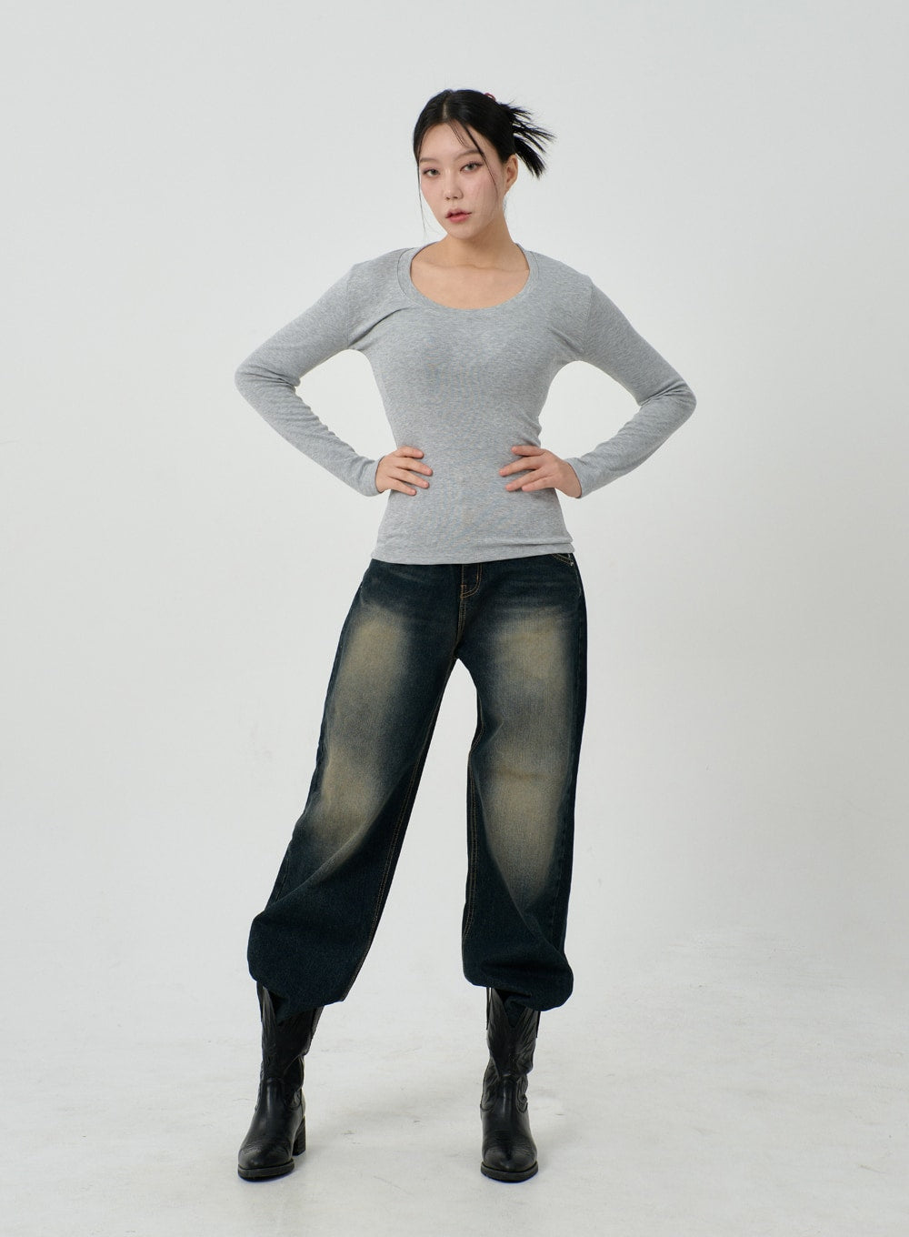 Vintage Washing Baggy Jeans ID23 in dark indigo, full-body front on model hands on hips, wide-fit denim with heavy yellow fade wash, voluminous leg, paired with grey fitted top and black boots.