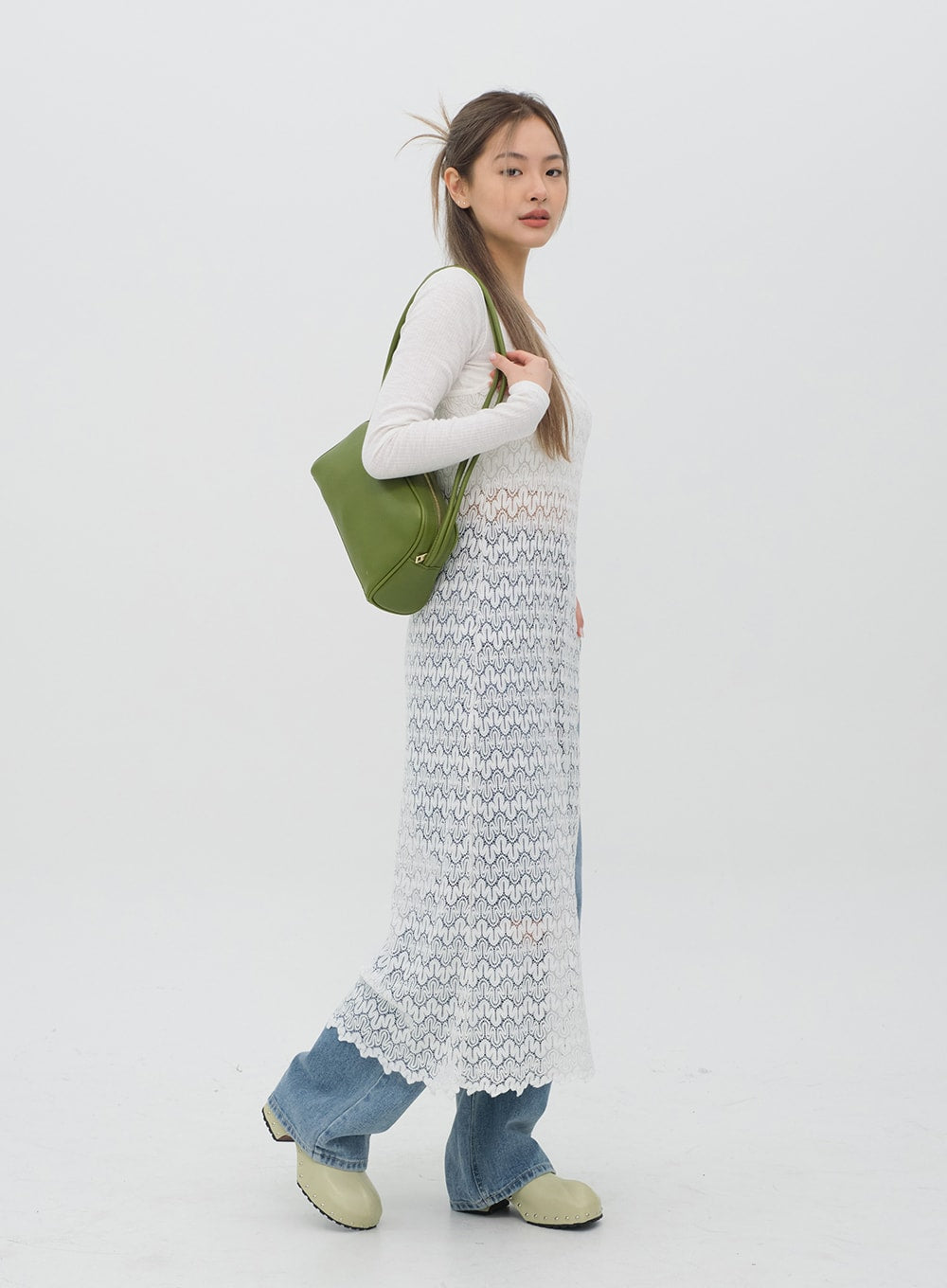 Torn Wide Leg Jeans C1002 in light blue, side profile full-length on model, wide-leg silhouette and hem length shown, layered with white lace dress, green shoulder bag.