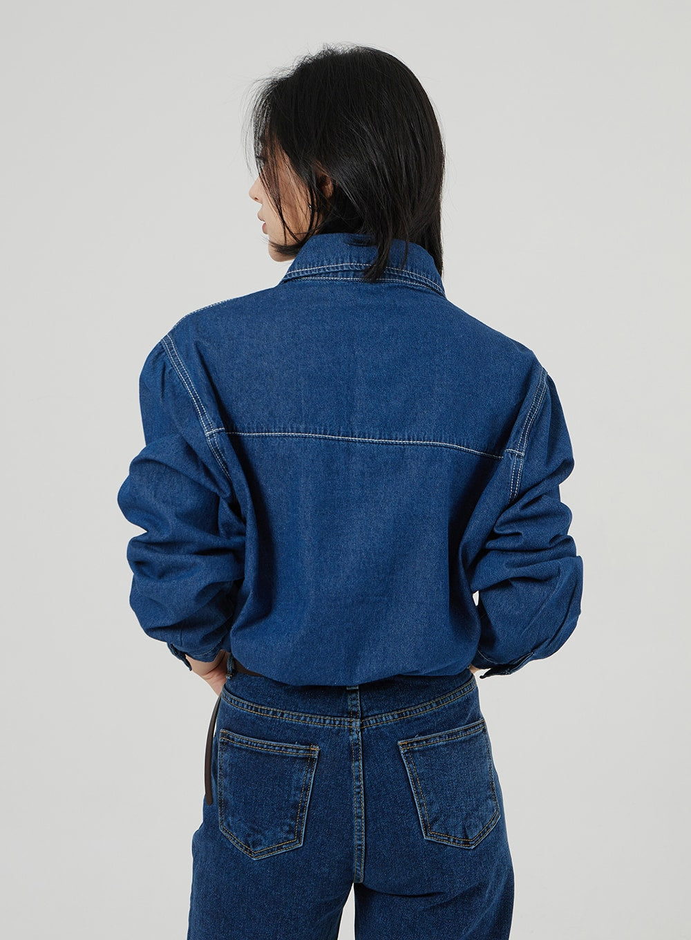Basic Indigo Jeans OF310 in indigo, back upper-body shot on model, rear yoke waistband and dual back pockets visible, wide fit, styled with denim shirt showing contrast topstitching.