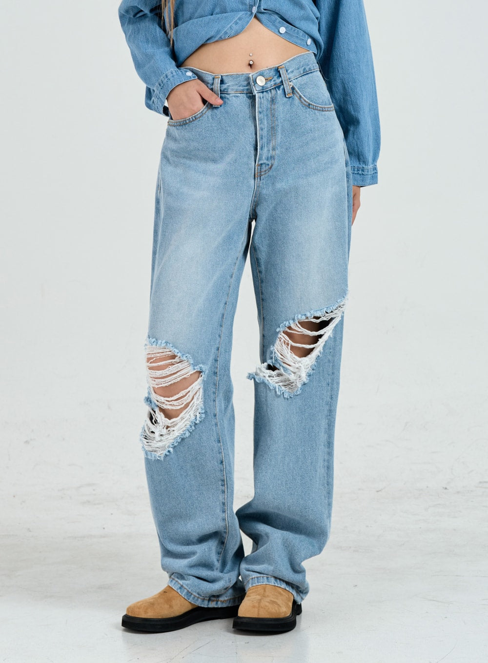 Ripped Maxi Denim Pants Unisex CO14 in light blue, front waist-to-hem close-up on model, wide-fit cotton denim with large frayed ripped knee detailing and five-pocket construction.