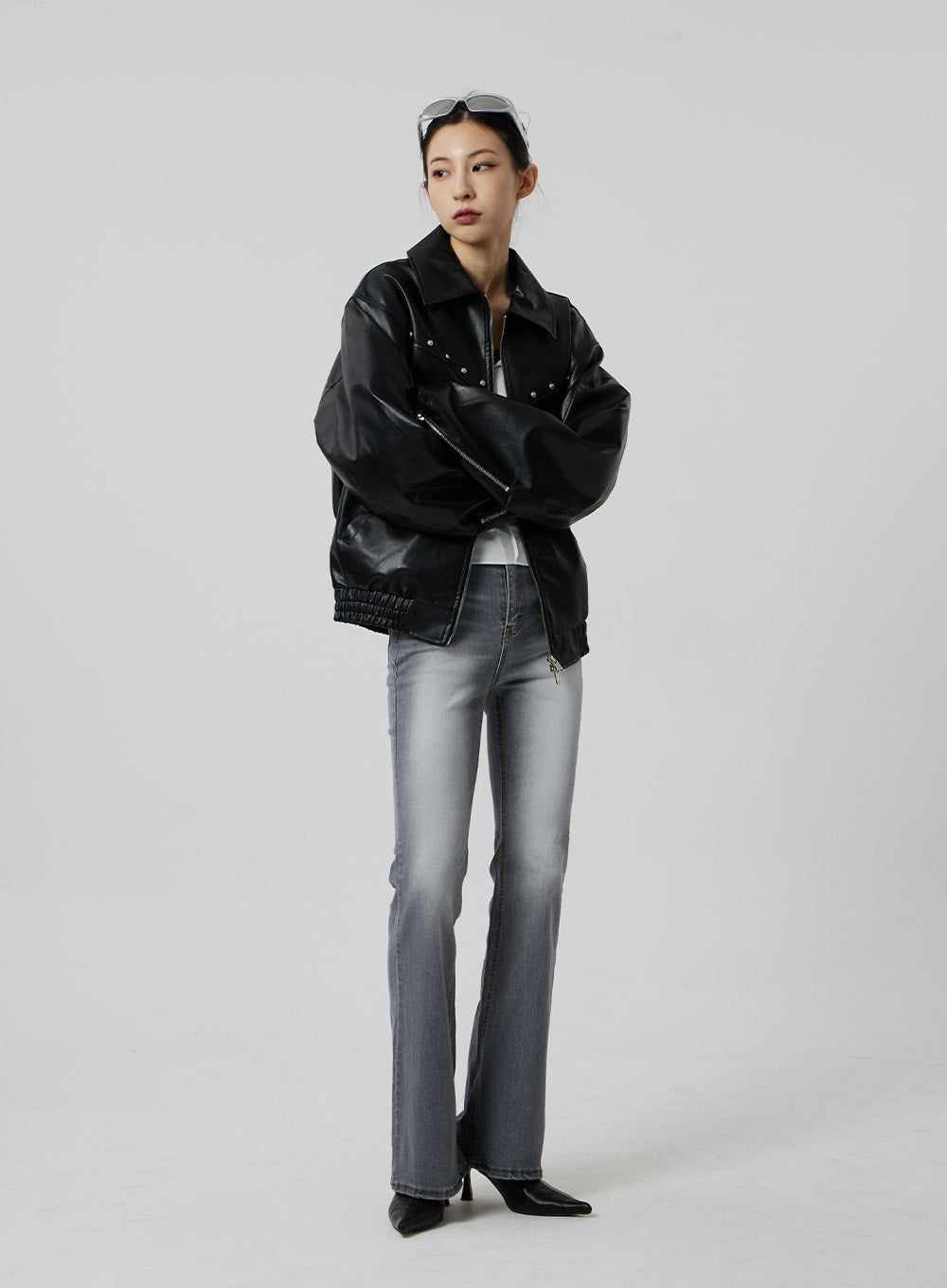 Slim Fit Bootcut Jeans CF307 in grey, full-length front view on model with arms crossed, showcasing elongated bootcut leg, paired with black faux-leather jacket and kitten heels.