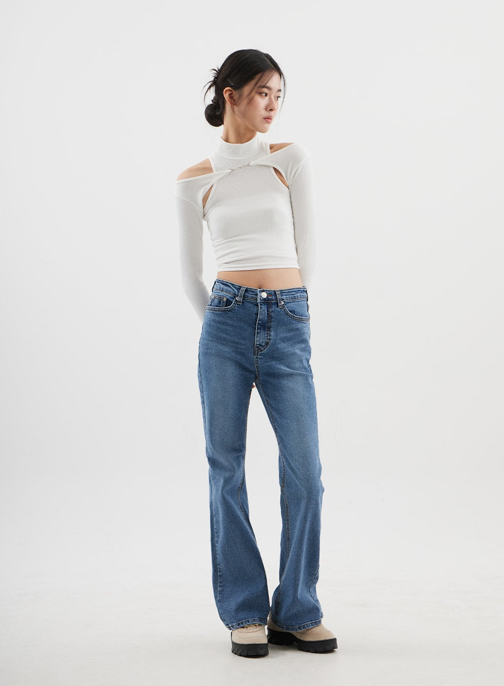Slim Fit Bootcut Jeans CJ311 in medium blue, slight side-front angle full-length on model, relaxed pose with hands behind back, bootcut flare visible, casual styling.