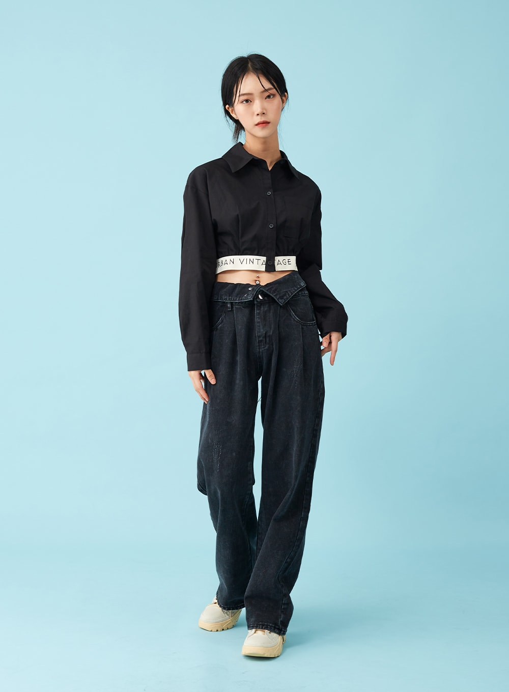 Four Buttoned Open Black Jeans CU8 in washed black, front full-body on model with slight pose variation, four-button open waistband exposed below crop shirt, wide cotton denim leg, chunky sneakers.