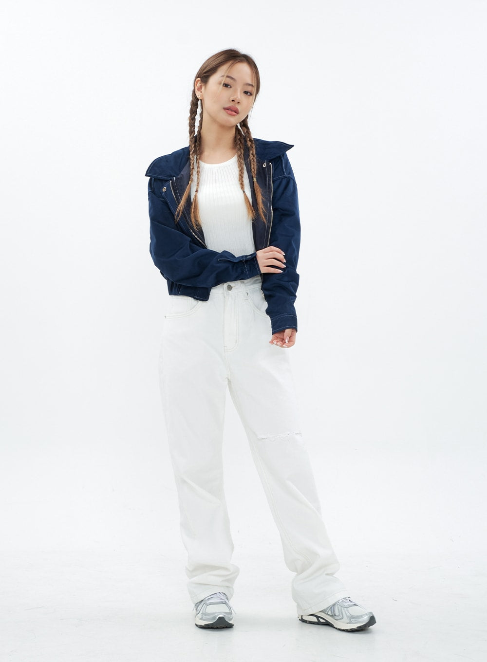 Torn Wide Leg Jeans CM18 in white, full-body slight front angle on model with arms crossed, wide-fit cotton with knee cut-out visible, styled with navy jacket and sneakers.