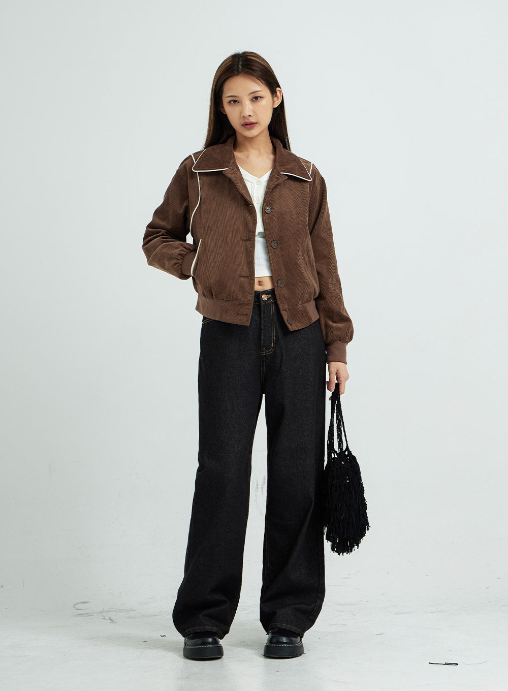 Pepe Wide Pants CS15 in black, full-length front view on model, wide-fit cotton denim with visible contrast stitching, layered with brown button-up jacket and white crop top.