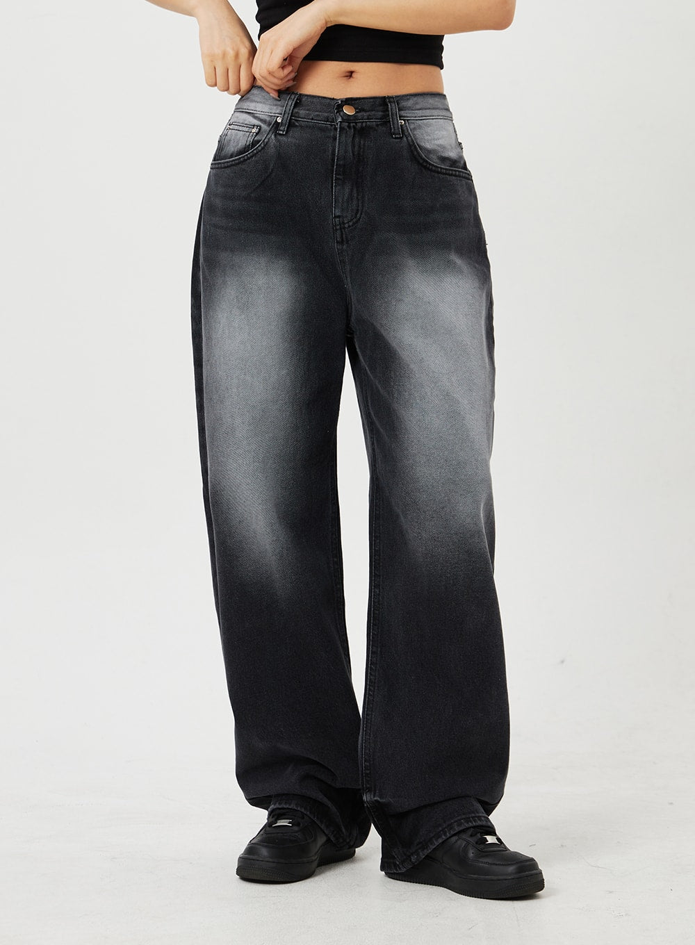 Mid-Rise Baggy Jeans CF328 in black, front close-up waist-to-hem view on model, wide-fit faded cotton denim highlighting mid-rise waistband, button fly, and five-pocket construction.