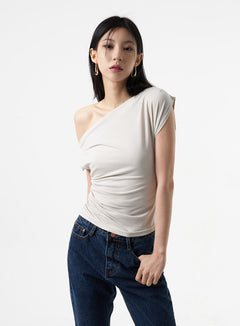 LEWKIN Cowl Neck Off-Shoulder Tee IA325 in light grey, front close-up on model, asymmetric off-shoulder neckline with draped cowl detail and body-skimming shirring, paired with dark flare jeans.