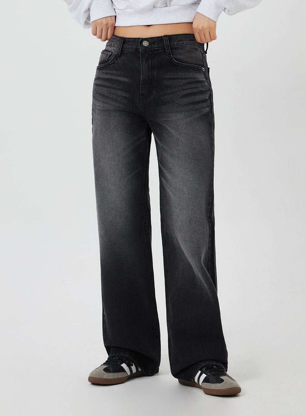 Mid-Rise Bootcut Jeans CF327 in black, front mid-section close-up on model, faded wash detail at thighs, mid-rise waistband and five-pocket denim construction visible.