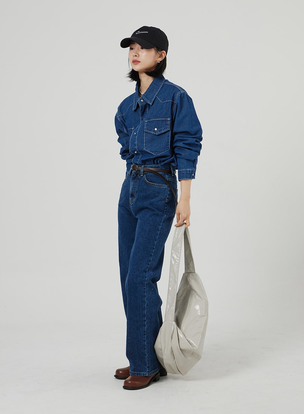 Basic Indigo Jeans OF310 in indigo, three-quarter side view on model, wide-leg silhouette with high waist, styled with denim shirt, brown leather belt, and gray tote bag.