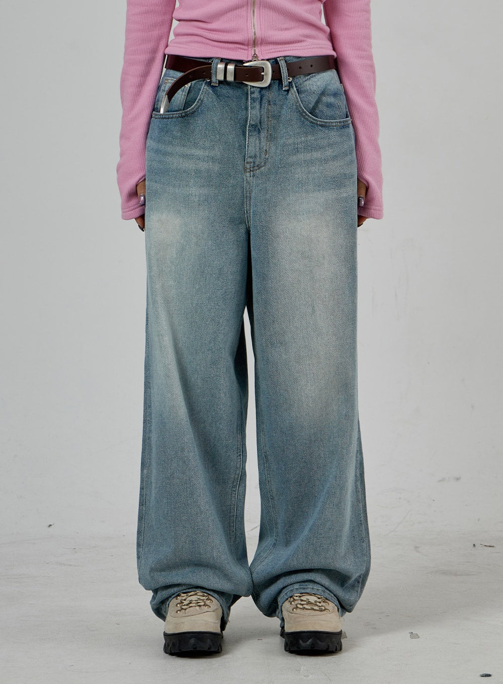 Light Wash Baggy Jeans Unisex CD26 in light blue, front mid-section close-up, five-pocket washed denim with sun-faded thigh panels and extra-wide leg, paired with double-prong belt.