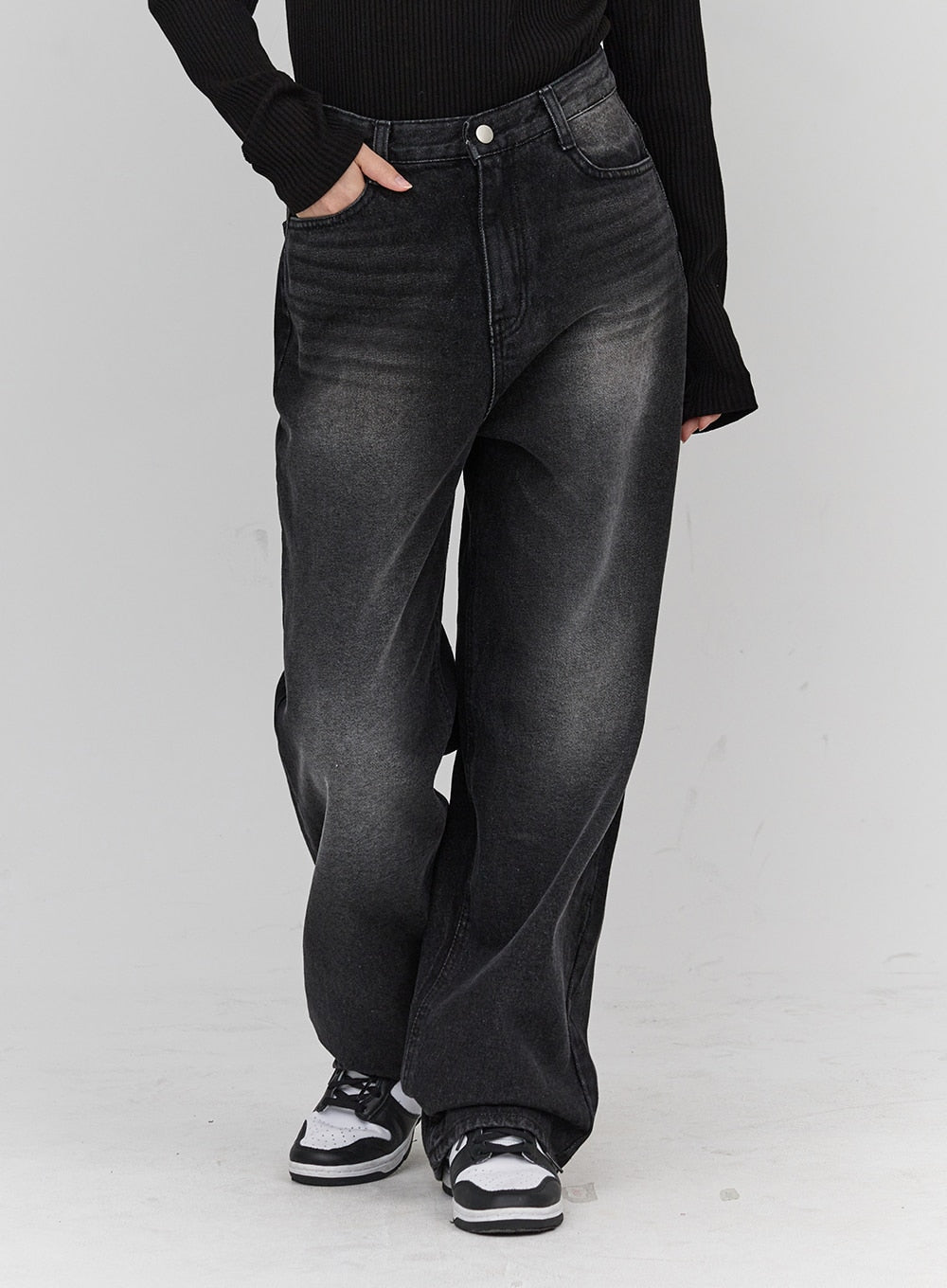 LEWKIN Light Washing Wide Leg Black Jeans CN23 in washed black, front close-up on model, wide-fit cotton denim with faded wash, paired with black ribbed top and sneakers.
