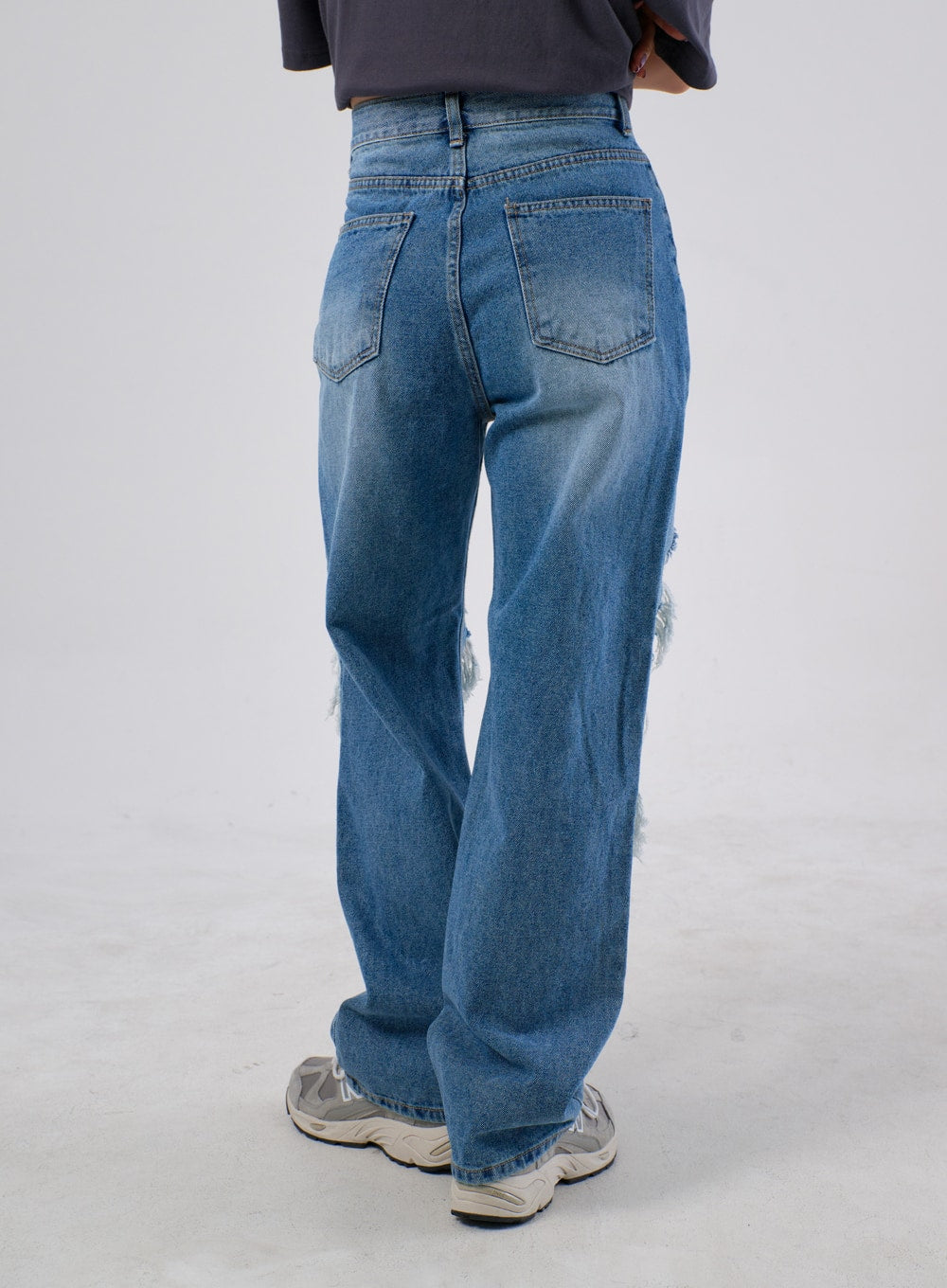 Ripped Knee Jeans IA305 in medium blue, back view on model, clean five-pocket construction with subtle fade wash and frayed rip visible at back of knee, wide straight leg.