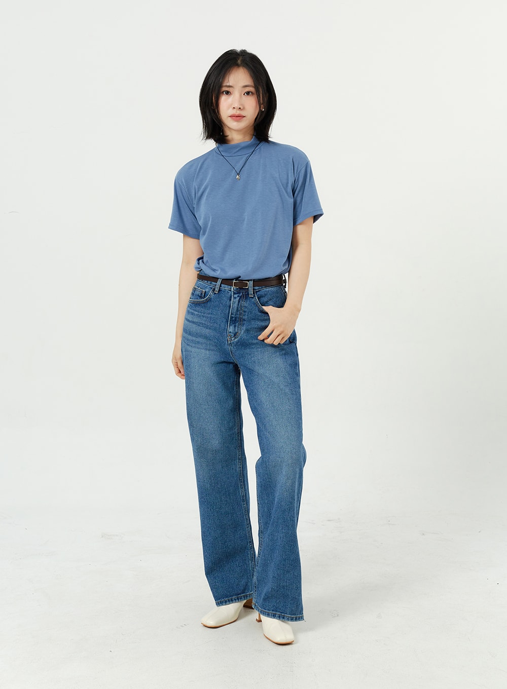 Side Slit Jeans OM308 in mid blue, full-length front shot on model, high-rise wide-fit cotton denim with side slits, styled with blue mock-neck tee and white boots.