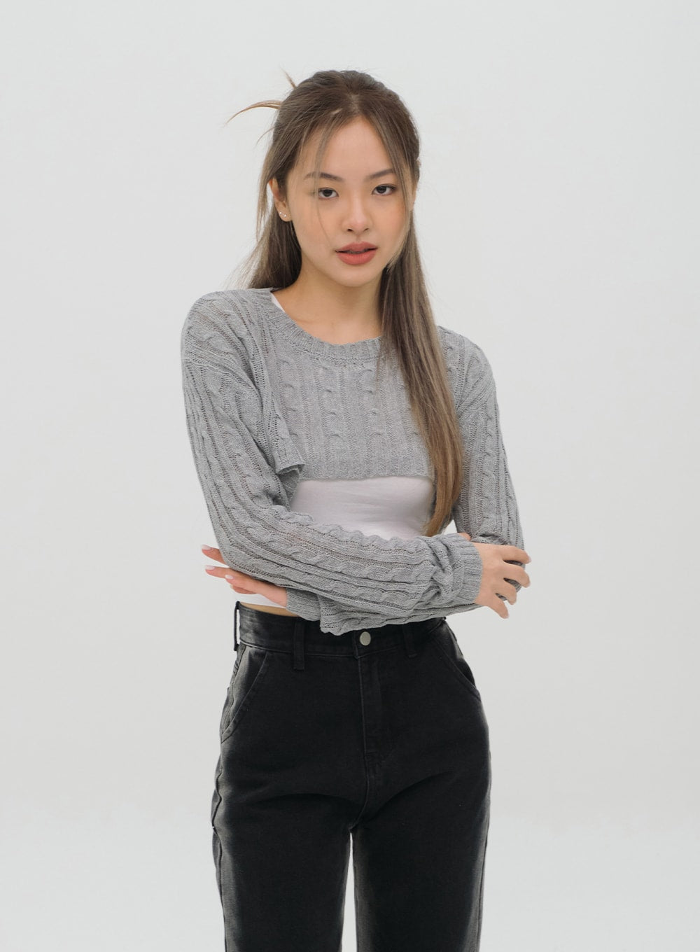 Black Jeans C1002 in washed black, upper-body close-up on model, high-rise waistband and button detail visible, wide-fit cotton denim, styled with grey cable-knit crop over white top.