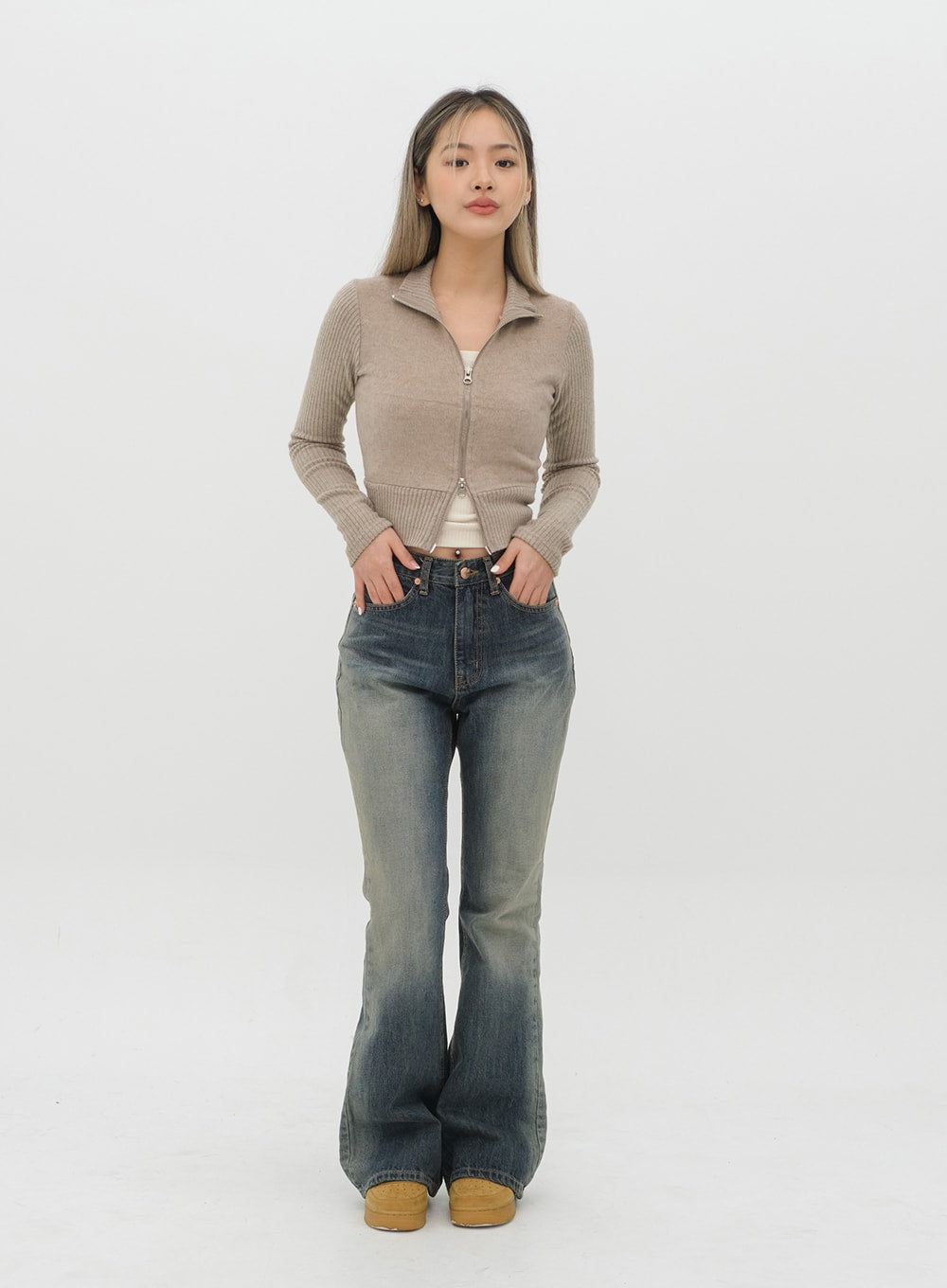 Boot Cut Jeans J20 in Dark Denim, full-length front on model hands in pockets, gradation washed cotton bootcut jeans, high-rise five-pocket styling with beige knit.