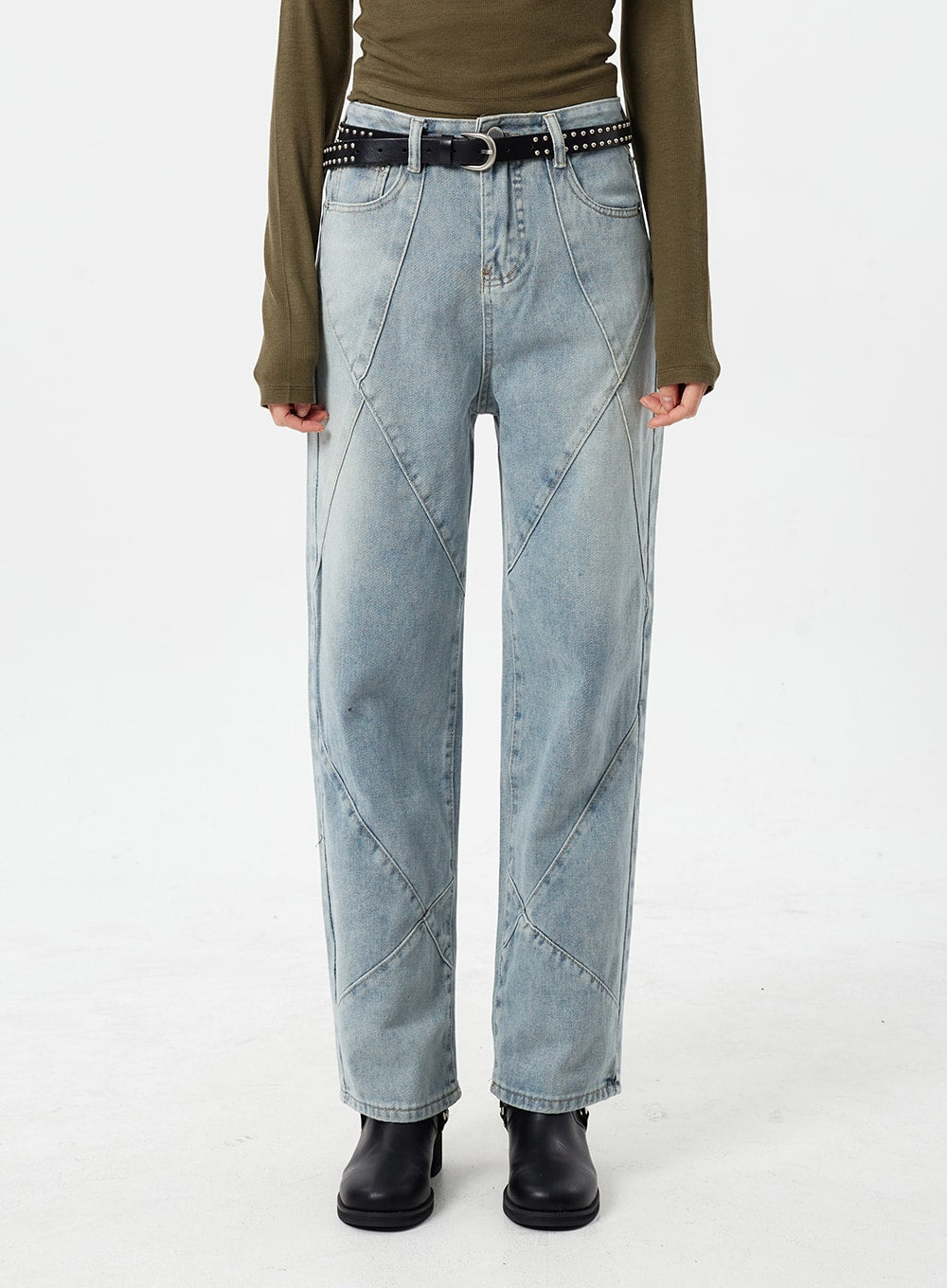 Light Wash Straight Leg Jeans CM307 in light blue, front close-up waist-to-hem on model, high-rise straight fit with intersecting geometric seams, worn with studded belt and olive long-sleeve top.