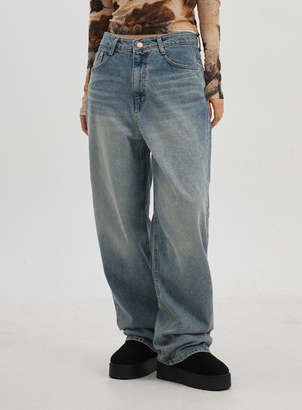 Low Rise Baggy Jeans CJ330 in Blue, waist-to-hem close-up on model, low-rise button closure and five-pocket detail, wide-leg cotton denim with vintage sun-faded wash.
