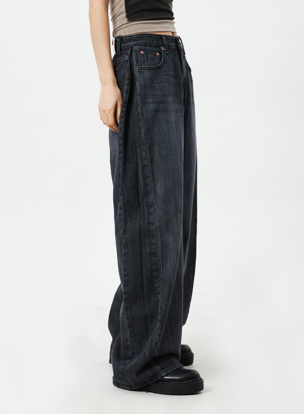 Mid-Rise Baggy Jeans CM324 in washed black denim, side view close-up on model, showing deep side silhouette and floor-length wide leg with faded wash detail.