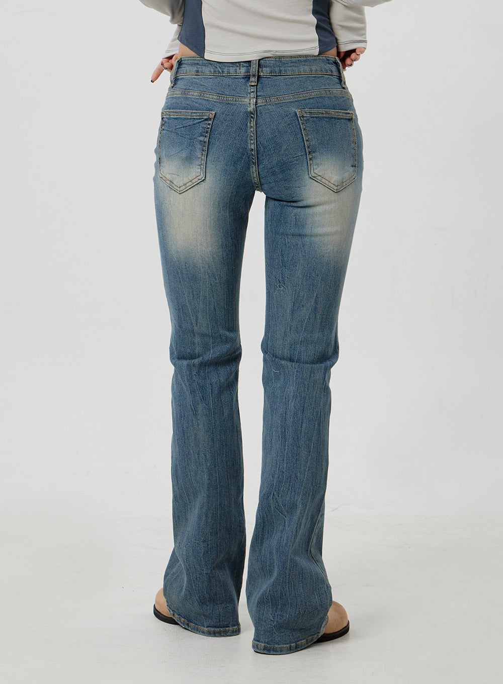 Low Rise Bootcut Jeans CF302 in blue, back view close-up on model, dual back patch pockets with faded wash, slim fit through seat, gentle bootcut flare at hem.