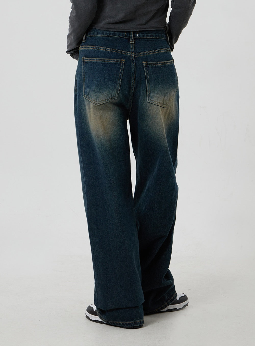 Dark Wash Jeans CF303 in blue, back close-up crop on model, deep indigo wide-leg denim showing back patch pockets and golden washed fading at seat and hem.