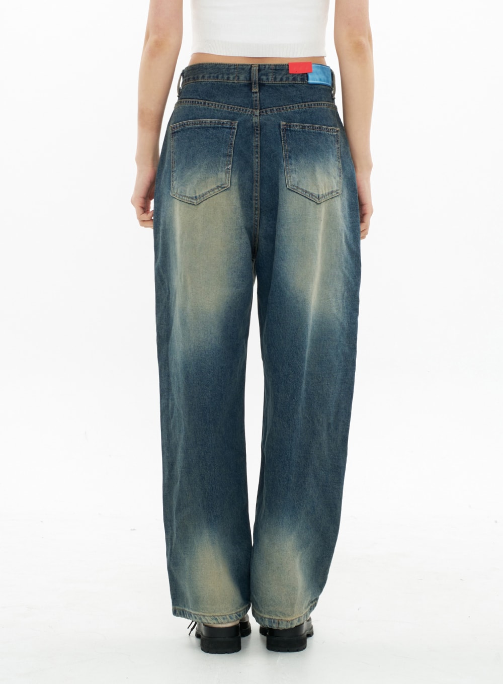 Bleached Wide Leg Denim Pants CA07 in vintage blue, back view on model, showing dual back pockets, colorblock label at waistband, and bleached gradation across wide-leg cotton denim.