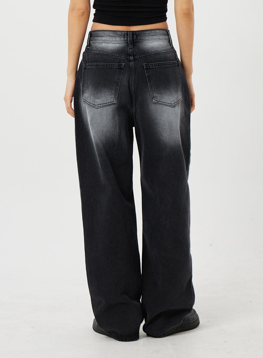 Mid-Rise Baggy Jeans CF328 in black, back view on model, wide-fit faded denim showing two patch back pockets and washed gradient finish, paired with black crop top.