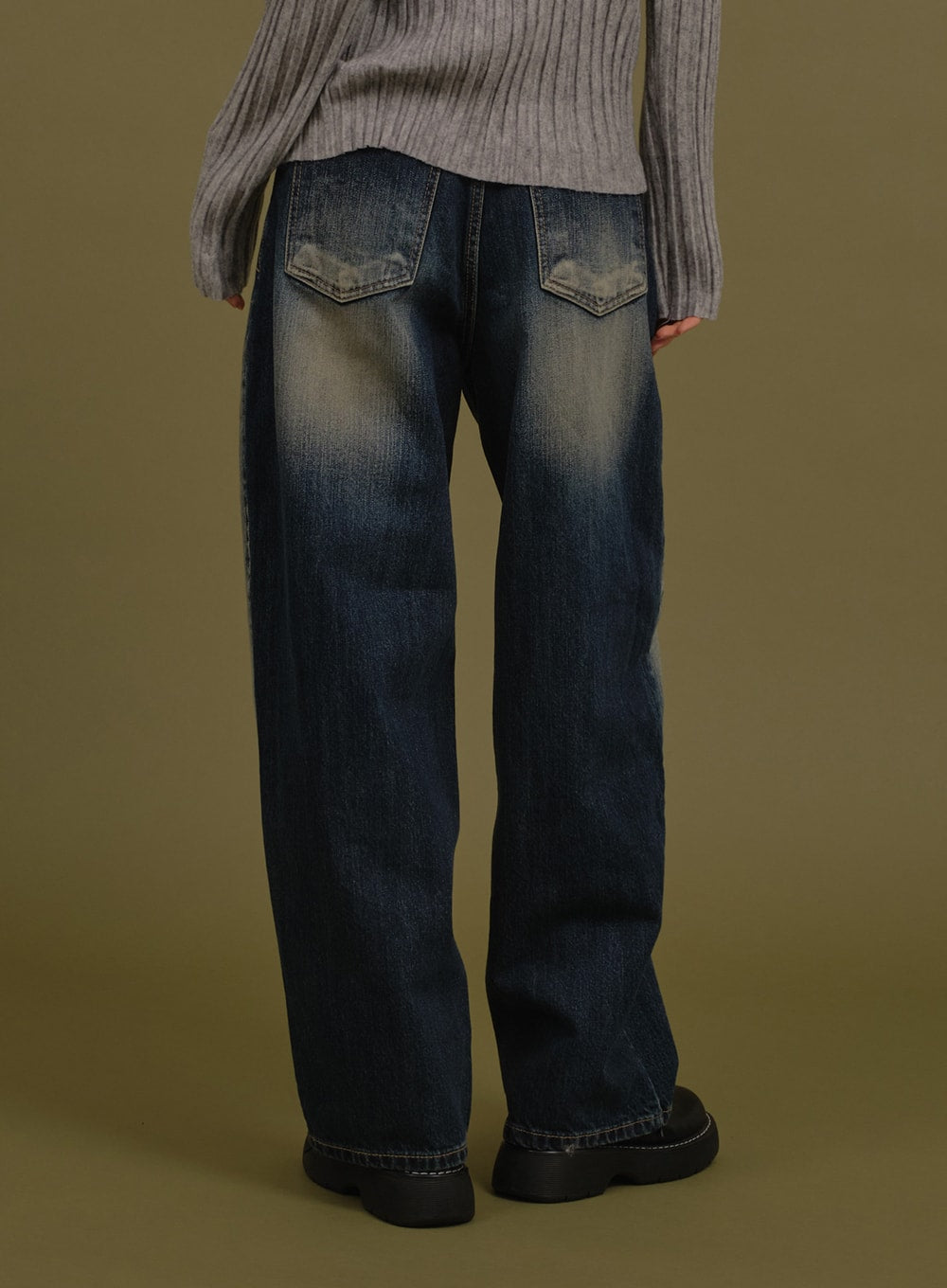 Washed Wide Denim Pants in blue, back view on model, showing back pockets with contrast stitching and washed gradation denim, paired with grey ribbed knit.