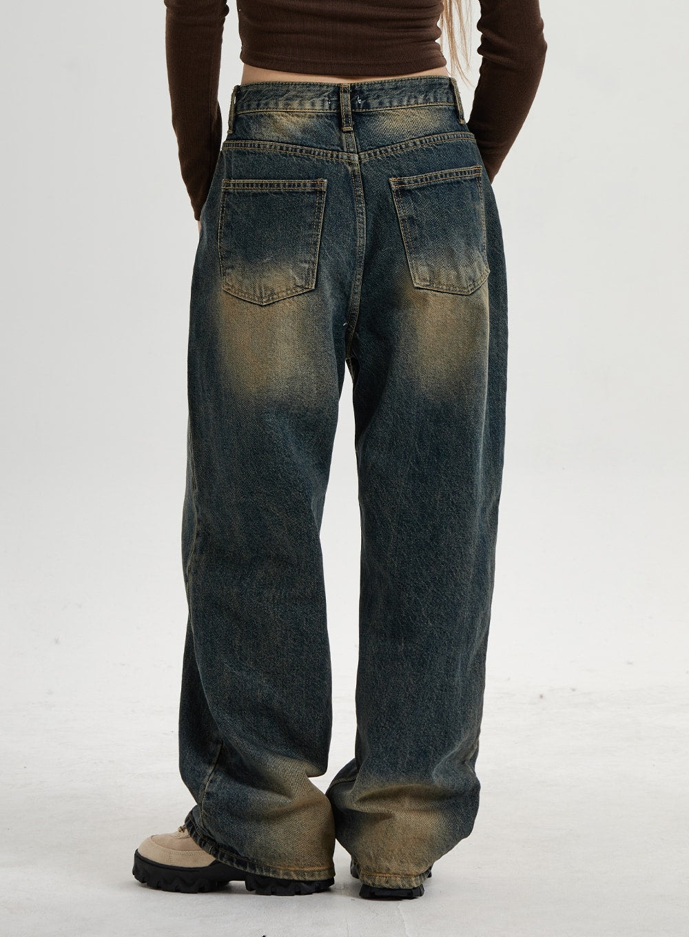Vintage Washing Wide Leg Denim Pants CN14 in vintage washed indigo, back view product-focus shot, two back patch pockets with yellow-brown vintage wash fade visible across wide leg hem.