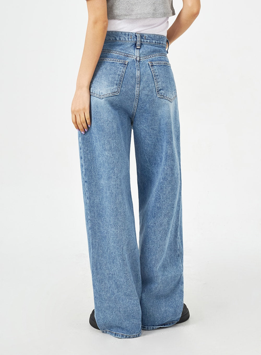 Mid-Wash Bootcut Jeans CM323 in mid blue, back three-quarter close-up on model, showing back patch pockets and wide-leg washed denim with subtle fading detail.