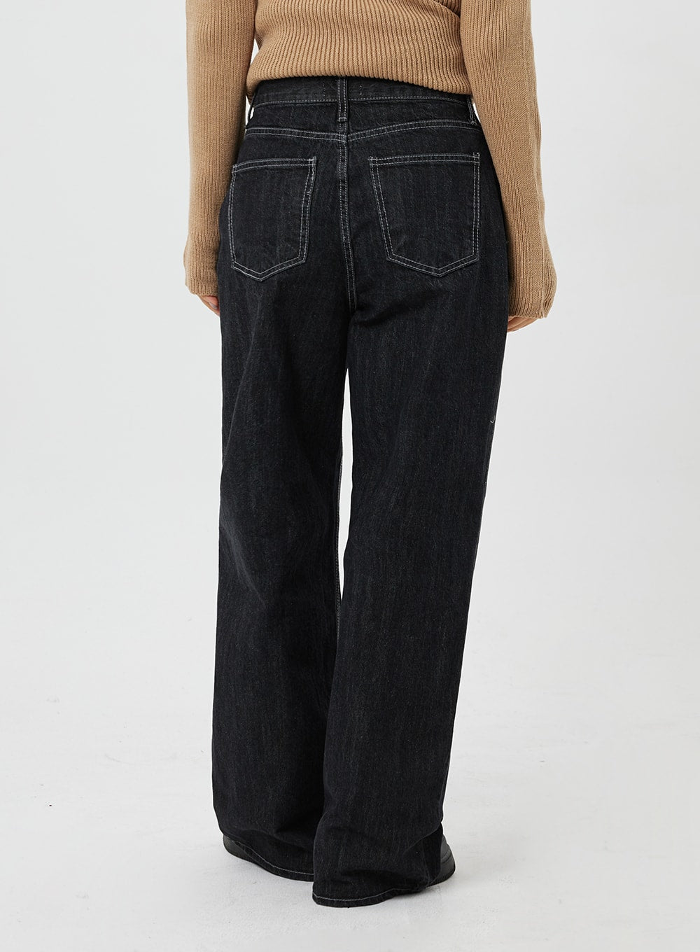Straight Leg Jeans CF315 in black, back view close-up on model, wide-fit denim with two back pockets and contrast topstitching, paired with camel knit.