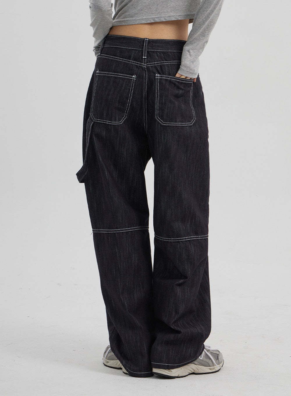 Mid-Rise Baggy Jeans CF307 in dark indigo, back close-up on model, large square back pockets with white contrast stitching, carpenter panel seam at knee, wide relaxed leg.