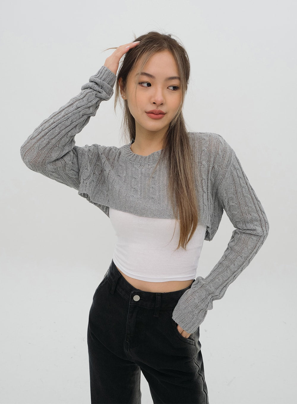 Black Jeans C1002 in washed black, upper-body three-quarter shot on model, high-rise waistband and front pocket visible, wide-fit solid denim, styled with grey cable-knit and white crop.