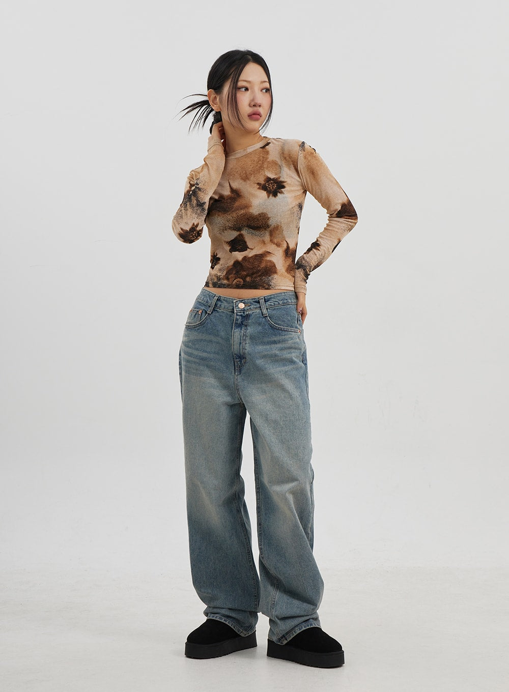 Low Rise Baggy Jeans CJ330 in Blue, full-body three-quarter front shot on model, relaxed baggy wide-fit denim with washed finish, styled with tie-dye top and black platform slides.