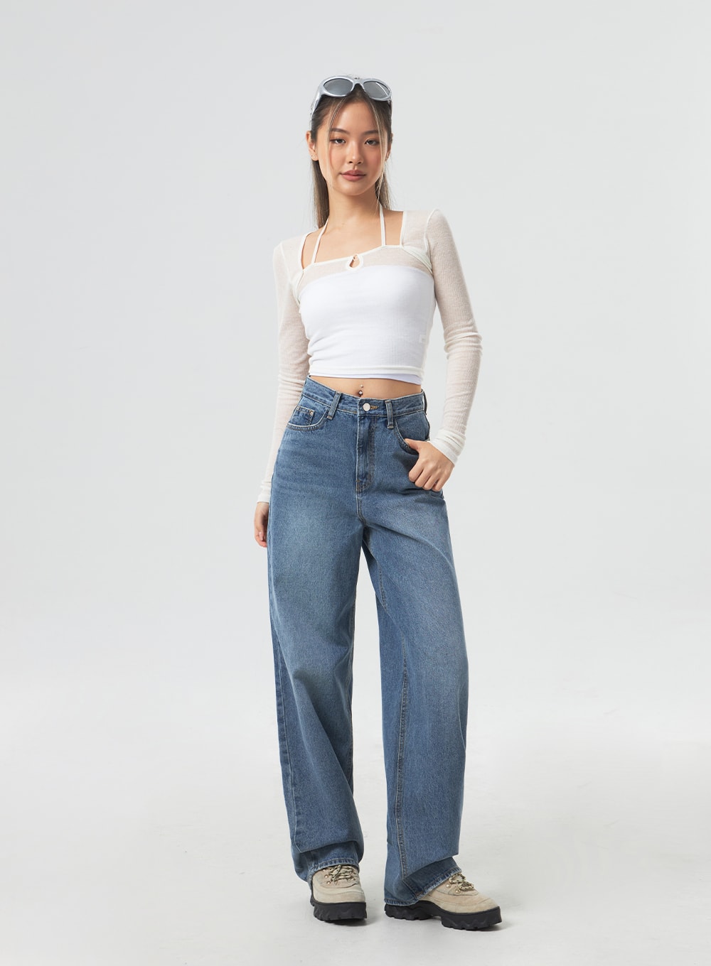 Wide Leg Mid-Wash Jeans CM331 in mid-wash blue, full-length front view on model facing camera, wide-fit casual denim with contrast stitching, paired with white mesh crop top and sunglasses.