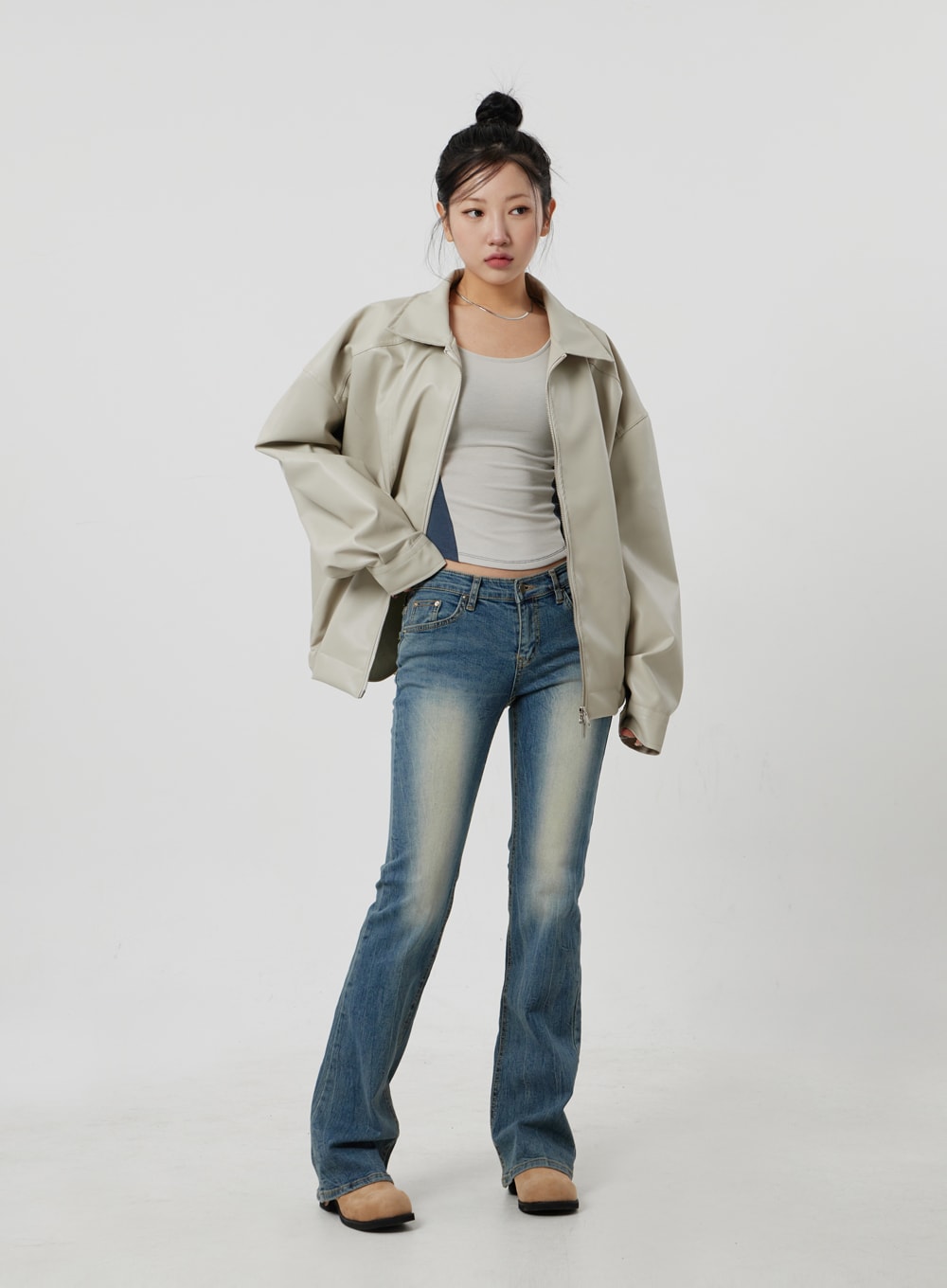 Low Rise Bootcut Jeans CF302 in blue, full-length front shot on model, low-rise bootcut denim with vintage sun-fade, styled with open beige jacket, white tank, and black loafers.