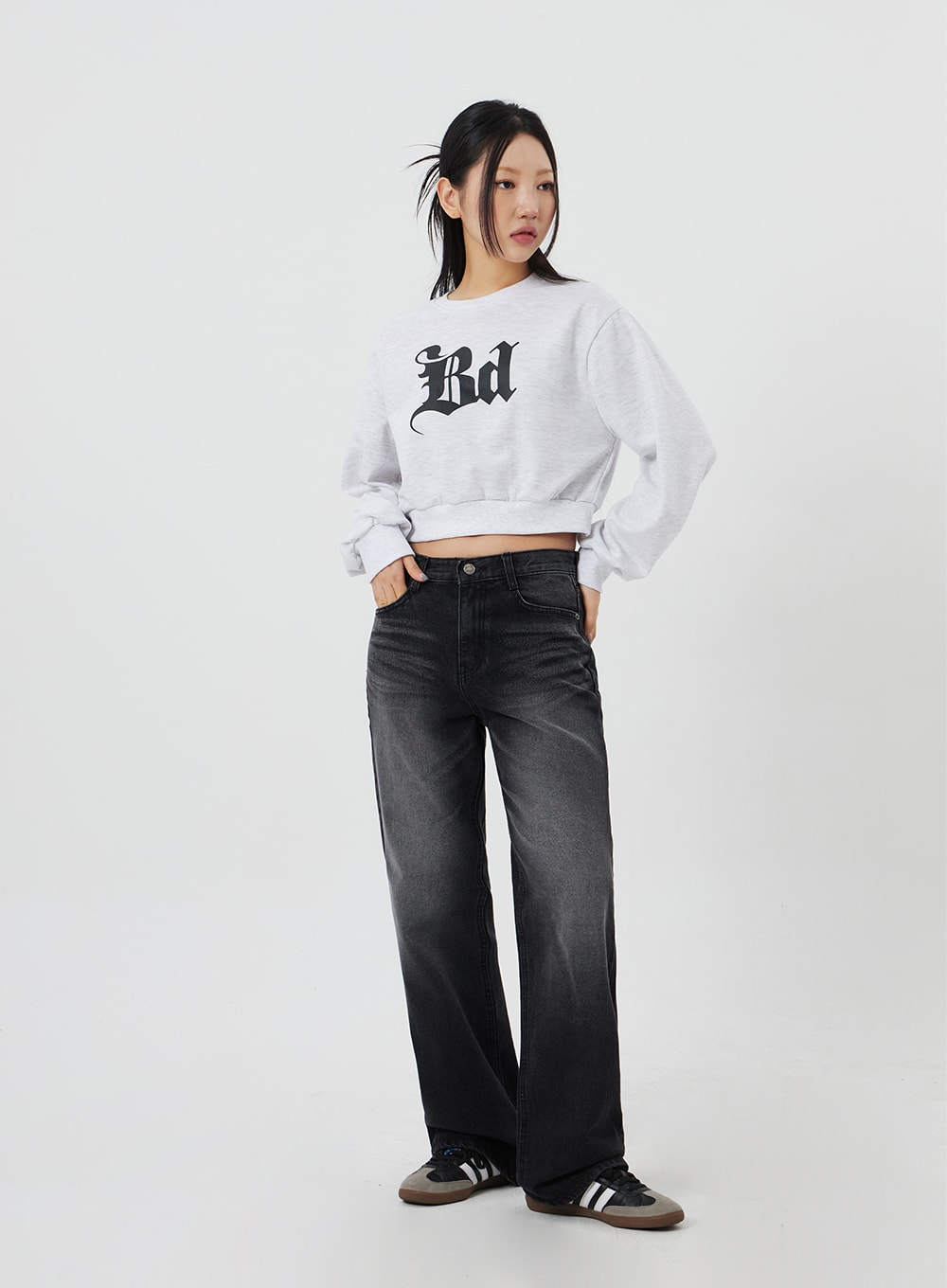 Mid-Rise Bootcut Jeans CF327 in black, full-body front on model with hand in pocket, relaxed casual pose showing full-length bootcut silhouette, paired with grey crop sweatshirt.