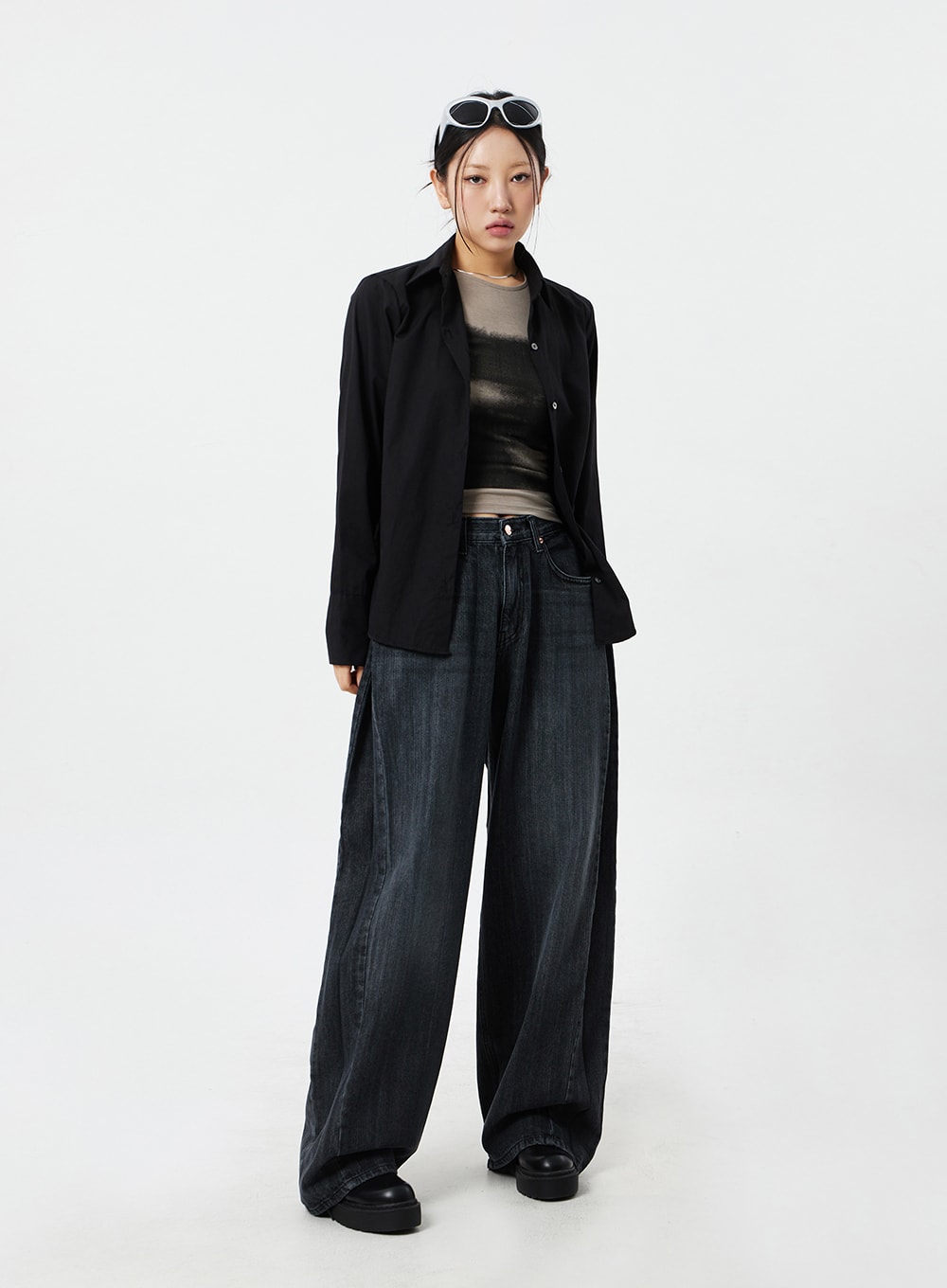 Mid-Rise Baggy Jeans CM324 in washed black denim, full-body front view on model, relaxed wide-fit leg with subtle fading, layered under black button-down shirt.