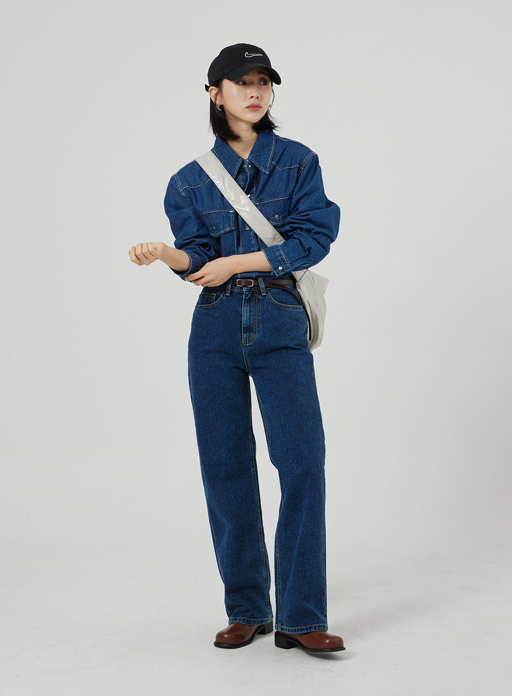 Basic Indigo Jeans OF310 in indigo, full-length front on model with crossbody bag, high-waist wide-fit cotton denim, contrast stitching, worn with denim shirt, black cap, and brown boots.