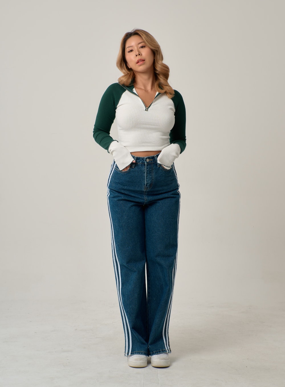 Side Stripes Straight Leg Jeans IN22 in mid blue, front full-body shot on model with hands in pockets, wide-fit straight leg denim with white triple side stripes, high-rise waist, casual pose.