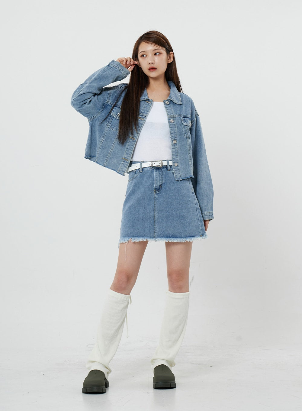 Sienna Crop Jeans Jacket CS21 in light blue, full-length slight side front view on model with hand raised, open crop denim jacket over white tank and denim mini skirt, styled with white knee boots.