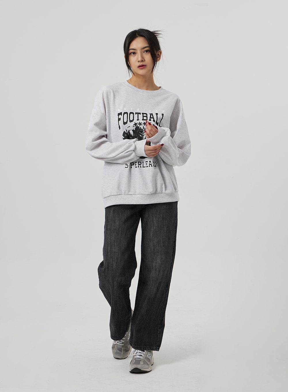 Wide Straight Leg Jeans BF310 in washed black, full-length front view on model with hands clasped, relaxed wide-fit denim paired with oversized grey football graphic sweatshirt.
