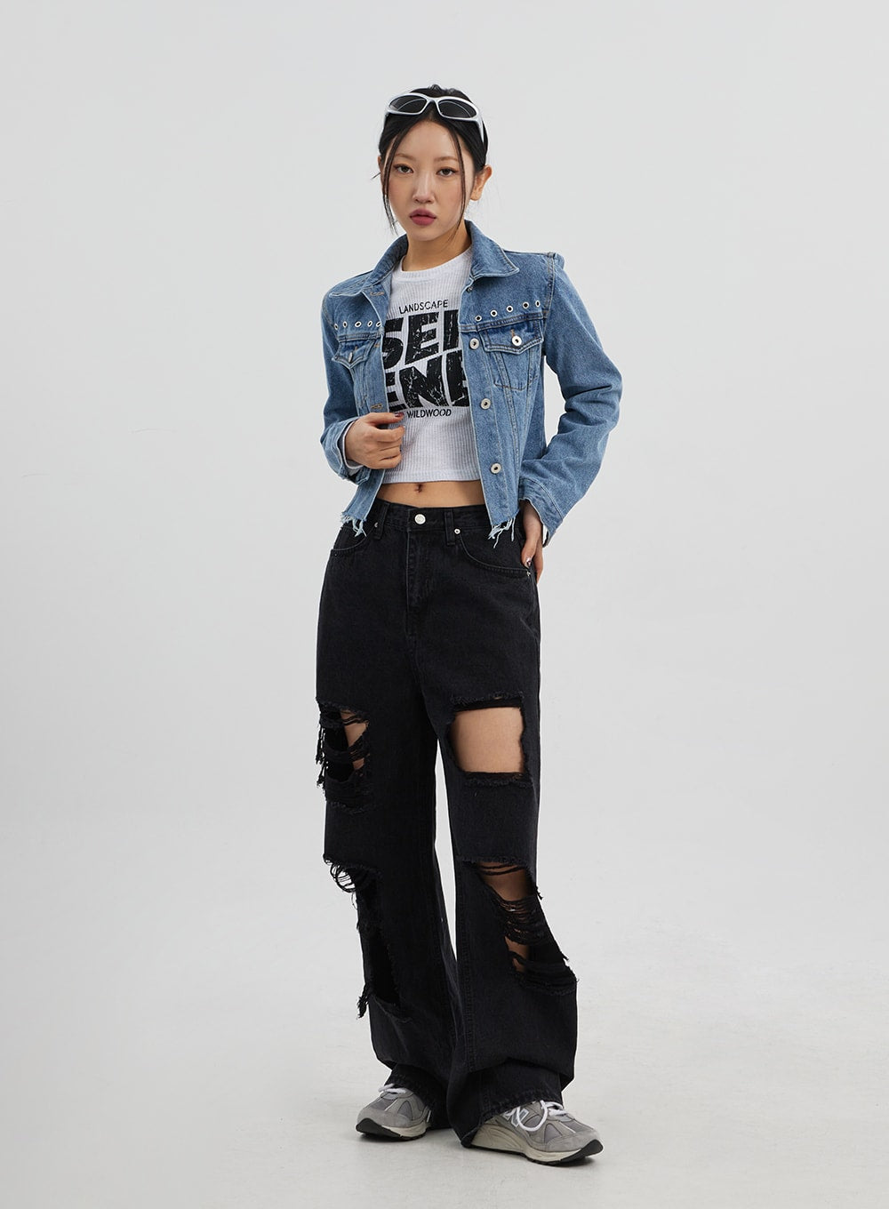 Ripped Wide Leg Jeans CJ319 in black, full-length slightly angled front on model, large thigh and knee rip cutouts with frayed edges, wide cotton denim leg, styled with blue denim jacket.