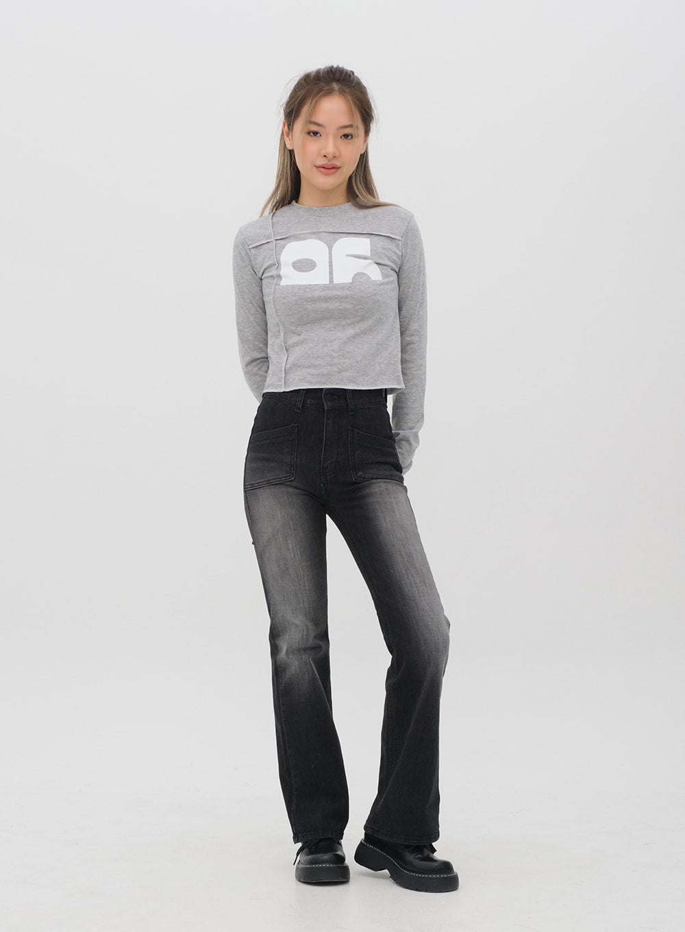 Bootcut Jeans M4 in black gradation wash, full-length front shot on model standing straight, long bootcut leg to floor, high-waist patch pockets, paired with grey graphic top.