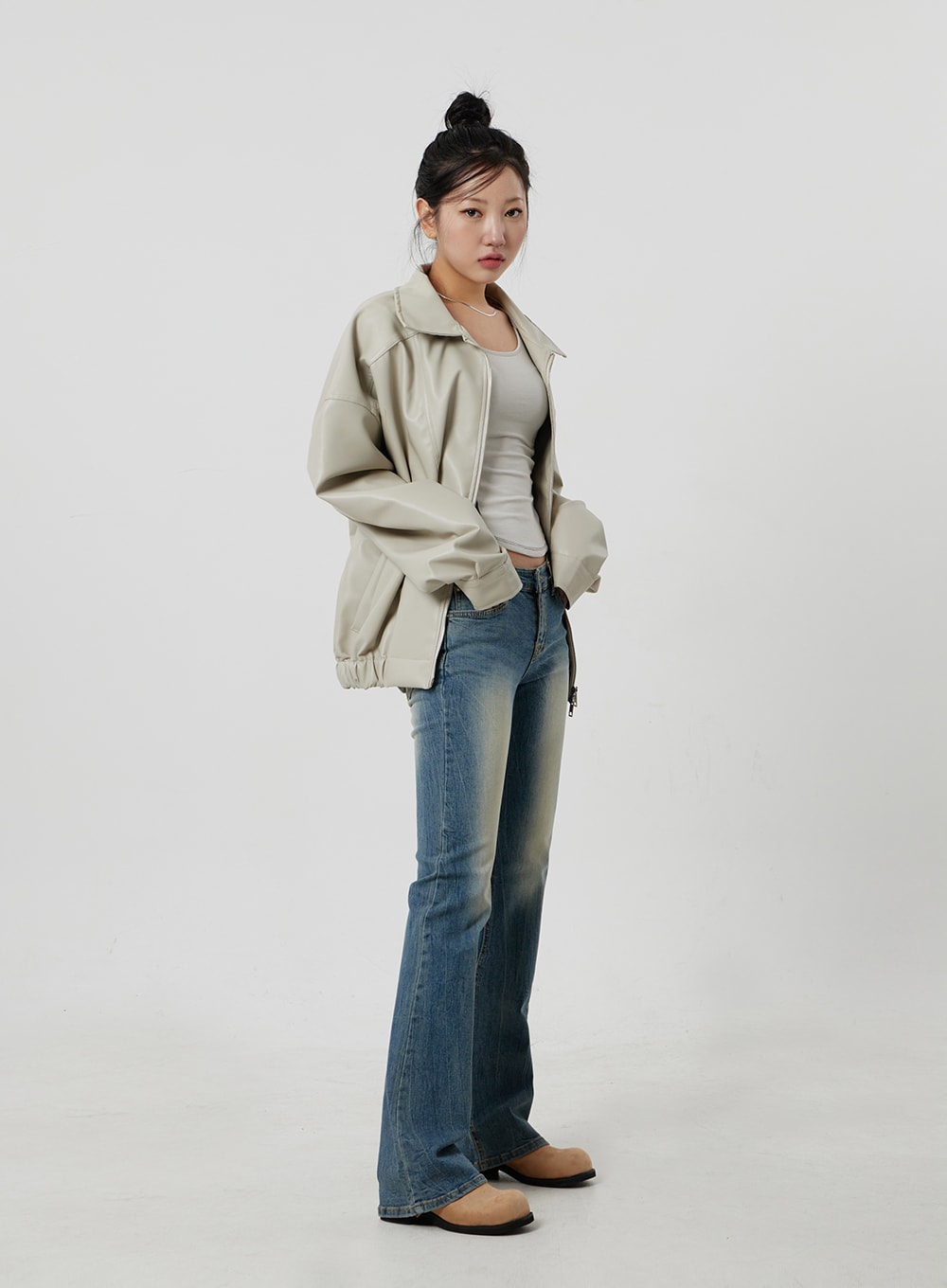Low Rise Bootcut Jeans CF302 in blue, full-length side shot on model, low-rise slim bootcut silhouette with faded wash, paired with beige zip jacket and tan mules.