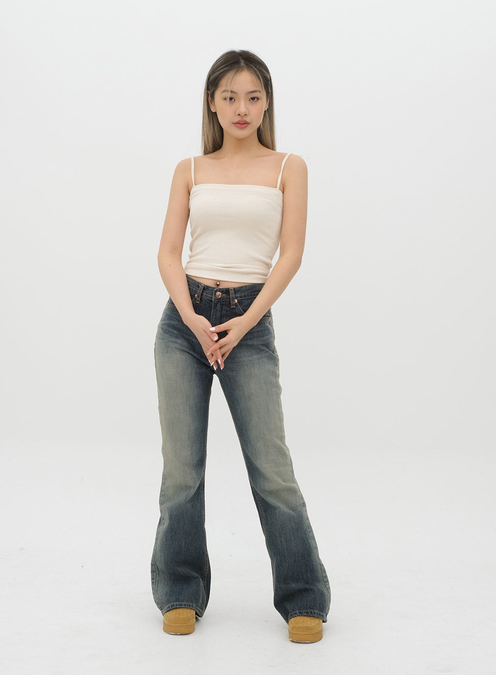 Boot Cut Jeans J20 in Dark Denim, full-length front on model in cream cami top, gradation cotton denim with bootcut flare, hands clasped at front, long inseam length.