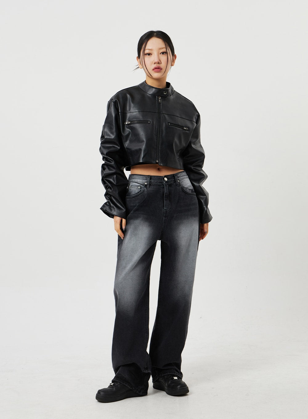 Mid-Rise Baggy Jeans CF328 in black, front full-length neutral stance on model, wide-fit faded denim with mid-rise waistband, paired with black cropped faux-leather jacket and platform sneakers.
