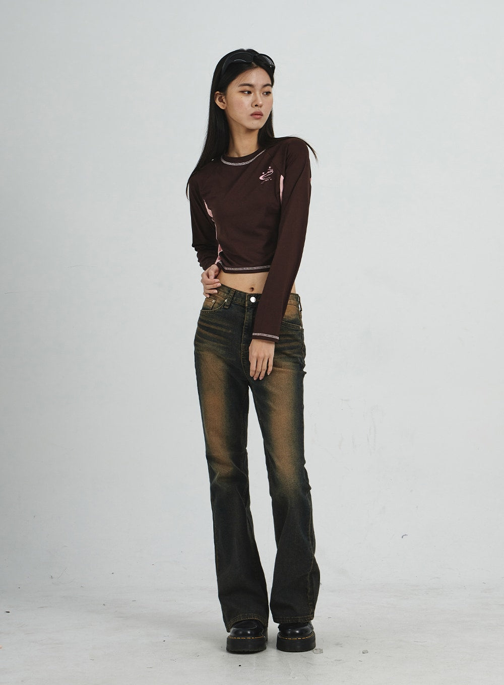 Vintage Washing Bootcut Jeans CD02 in dark washed denim, full-length three-quarter angle front view on model, hands clasped at waist, vintage amber wash on thighs and slim-fit bootcut leg.