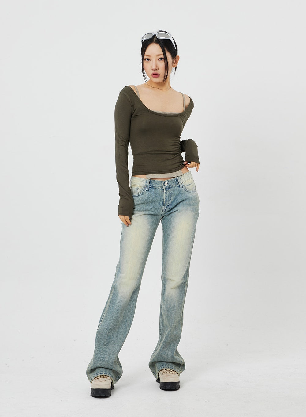 Low Rise Bootcut Jeans CF315 in light blue, front full-length shot on model facing camera directly, low waist cotton denim, bootcut flare at hem, paired with olive layered top.